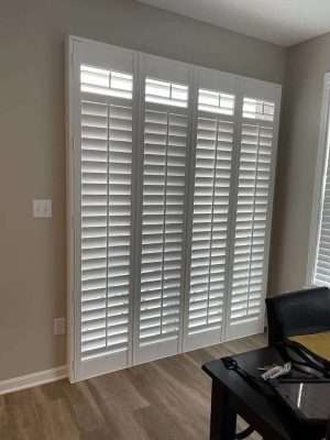 White plantation shutters in modern room.