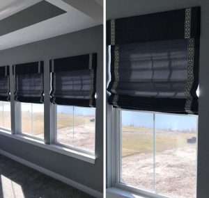 Windows with decorative black roman shades.